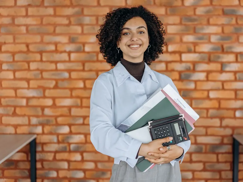 Contadora sonríe con sus carpetas y la calculadora