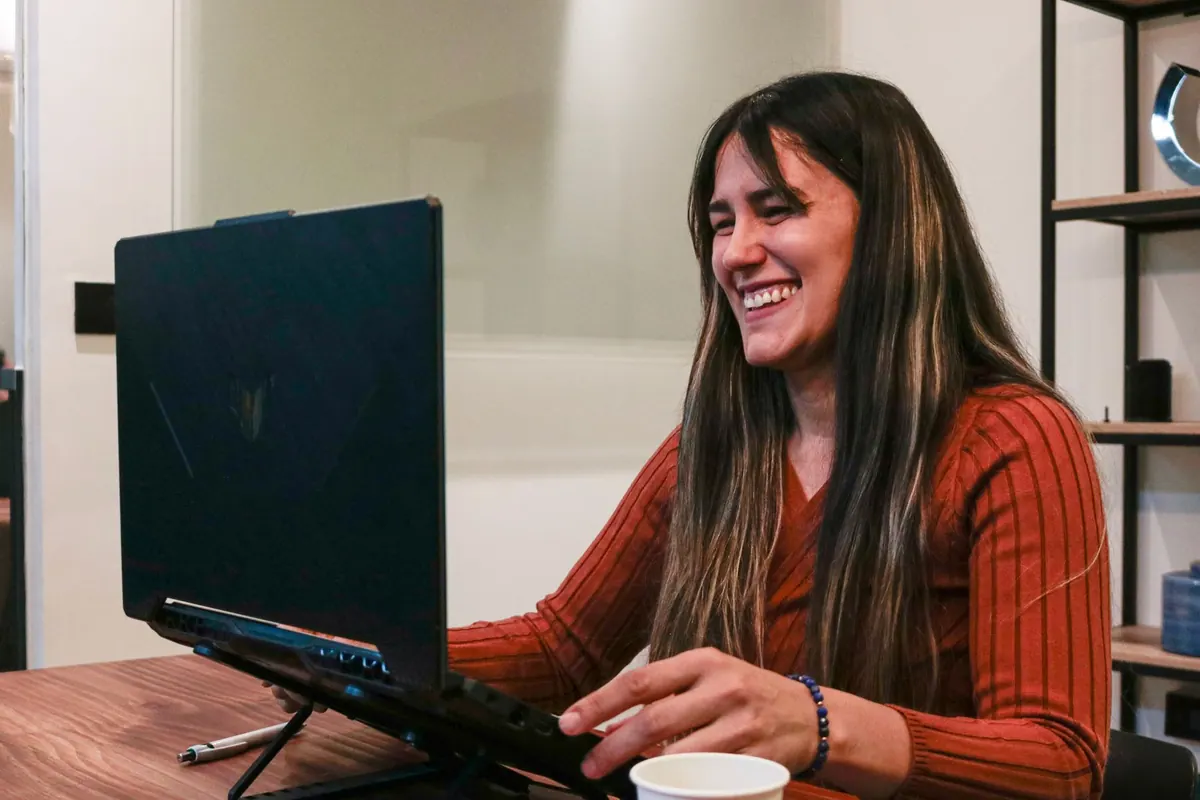 Emprendedora se ríe frente a su computador en su oficina