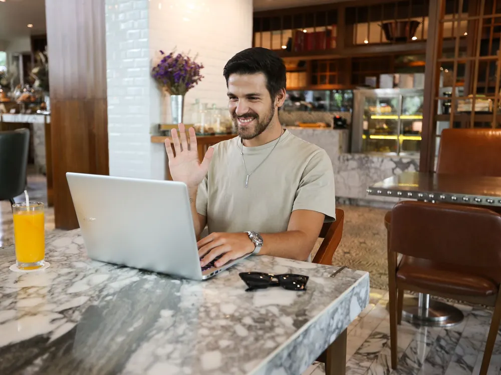 Emprendedor saluda en una videollamada desde su notebook