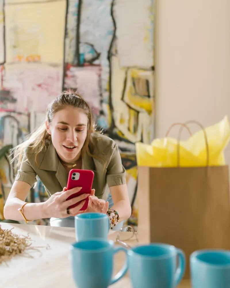 Emprendedora fotografía sus tazas con el celular para publicarlas